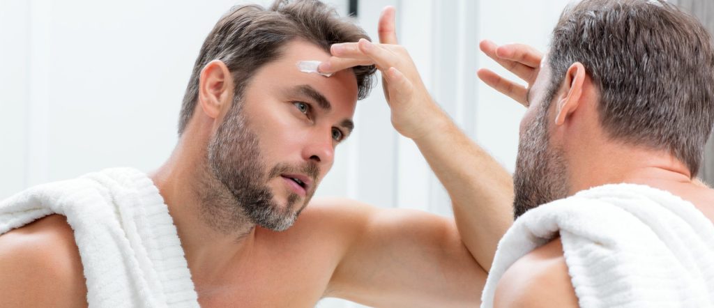 Hombre aplica crema antiarrugas