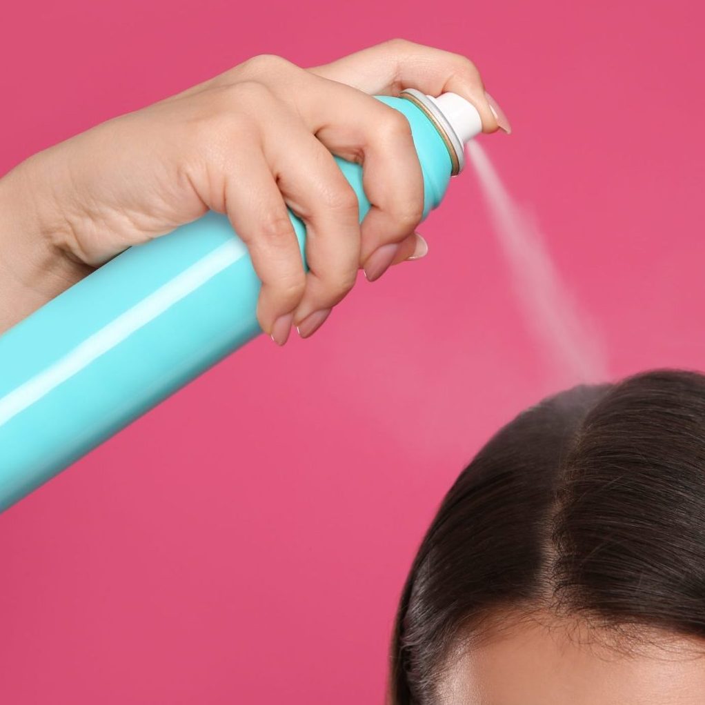 mujer aplicando champu en seco